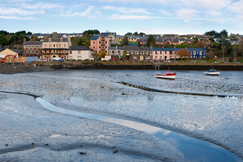 Colorful buildings line a harbor with small colorful fishing boats